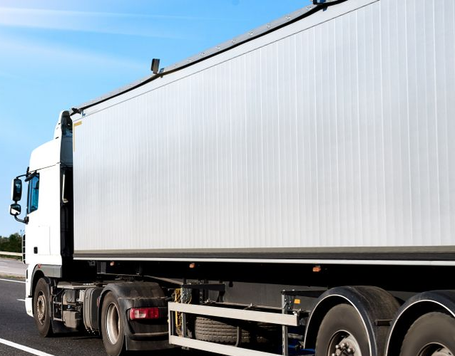 White Semi-truck With Trailer Driving on a Road Under a Blue Sky — Hines Logistic Pty Ltd In Brisbane, QLD