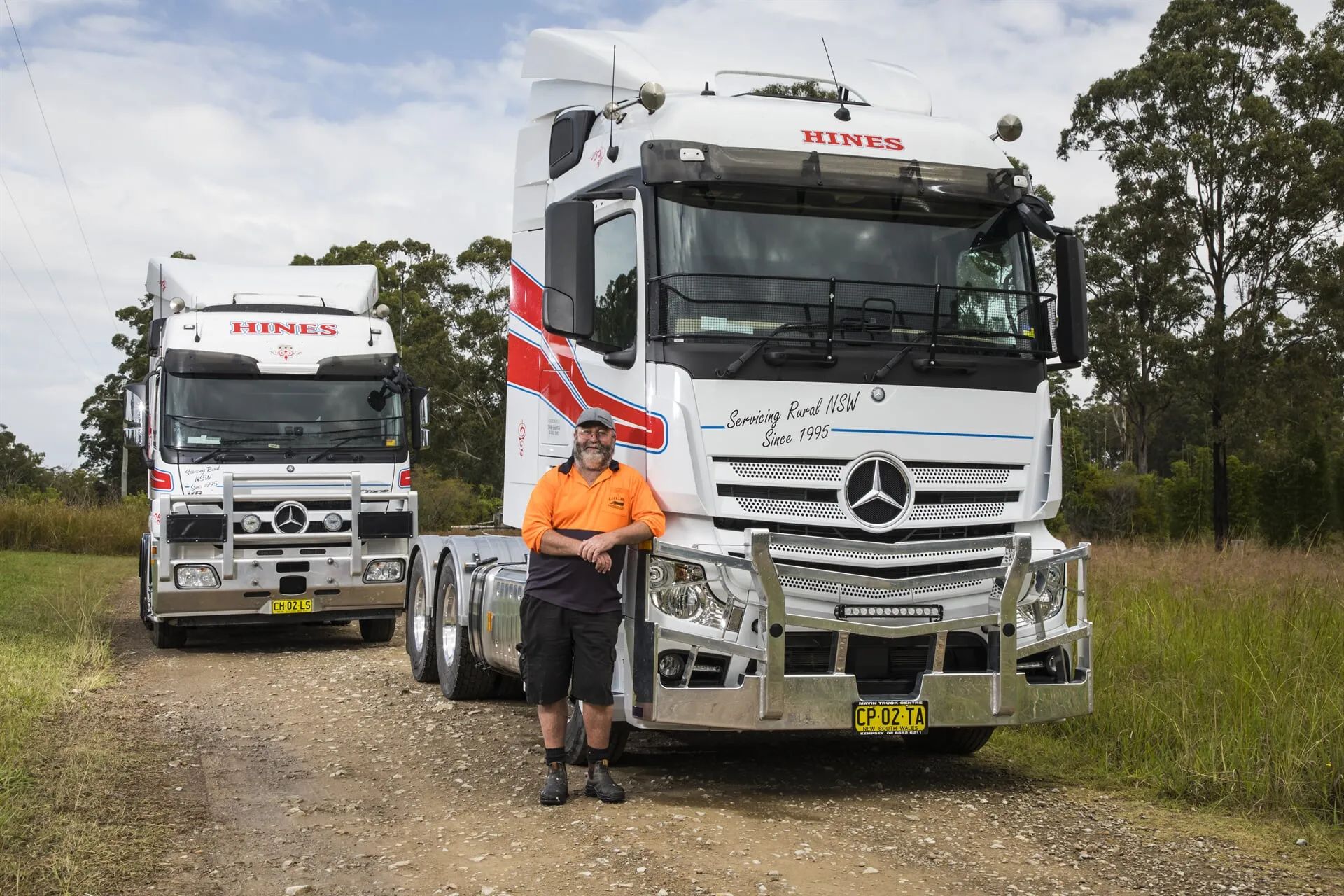 Man Standing Next to White Semi-truck With Rohan's Logo — Hines Logistic Pty Ltd In Kempsey, NSW