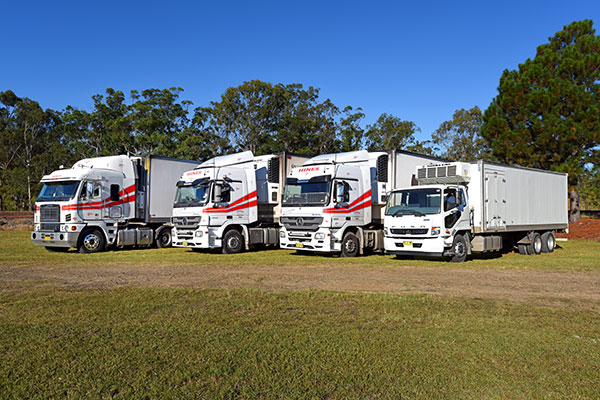 Four Refrigerated Trucks Parked on Grass 	— Hines Logistic Pty Ltd In Maitland, NSW