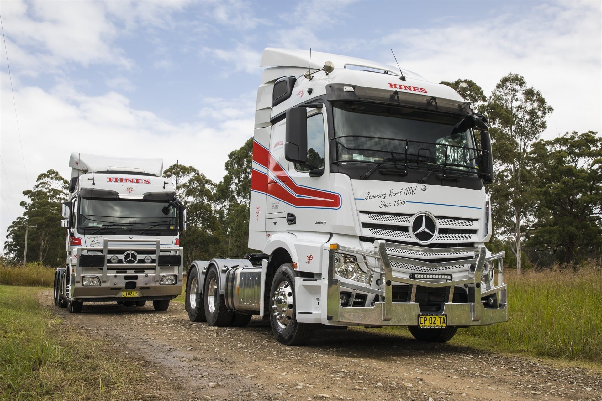 Two White Mercedes-benz Trucks on a Dirt Road; One in Front — Hines Logistic Pty Ltd In Newcastle, NSW