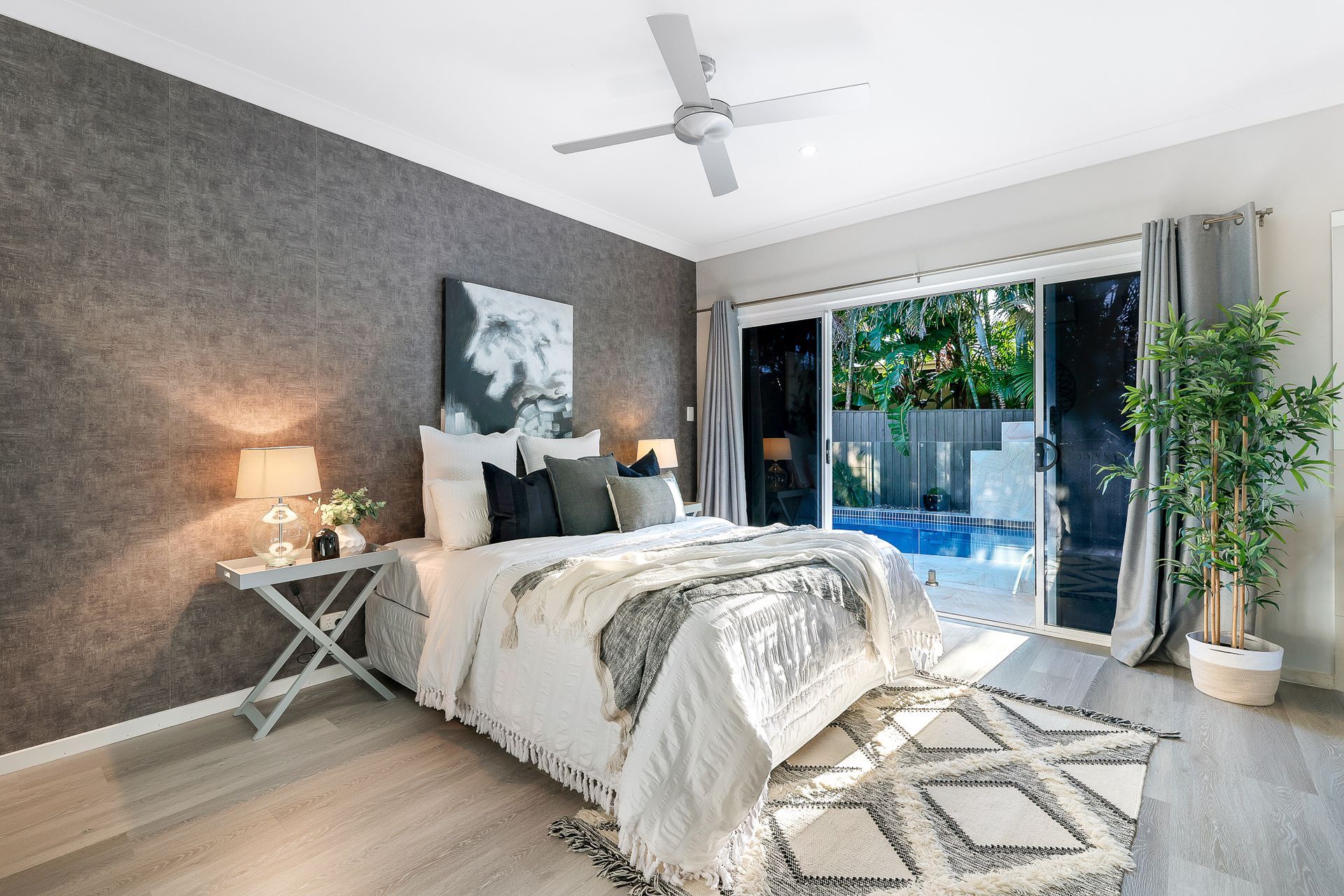 A bedroom with a large bed and a ceiling fan.