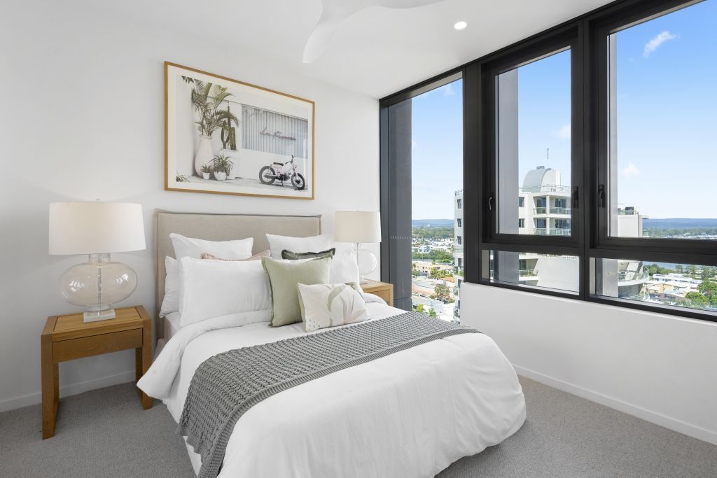 A bedroom with a large bed and a large window.