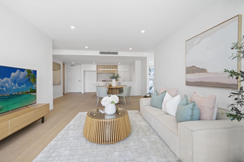 A living room with a couch , coffee table , and television.