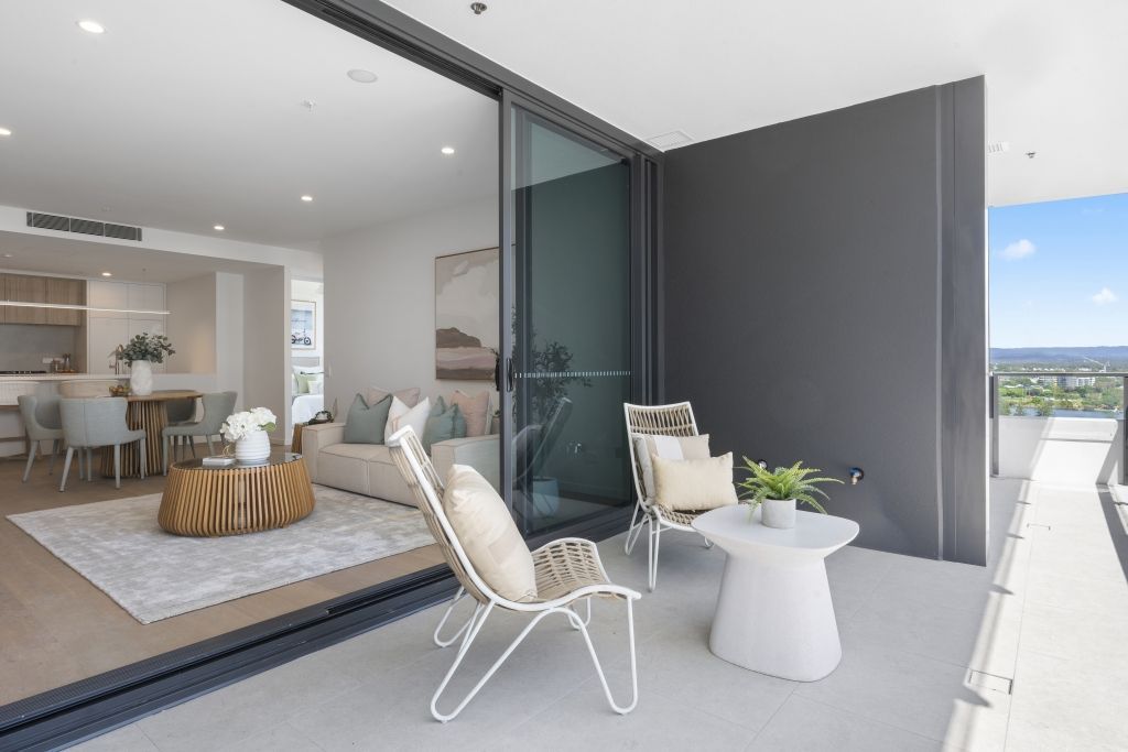 A balcony with chairs and a table in a living room.