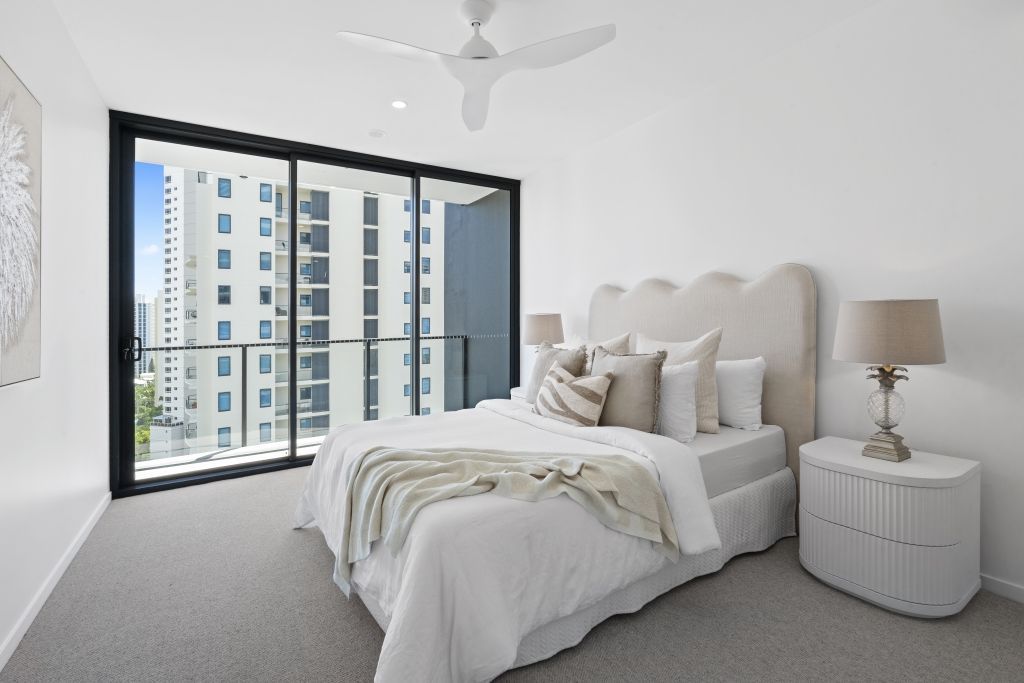 A bedroom with a large bed and a ceiling fan.
