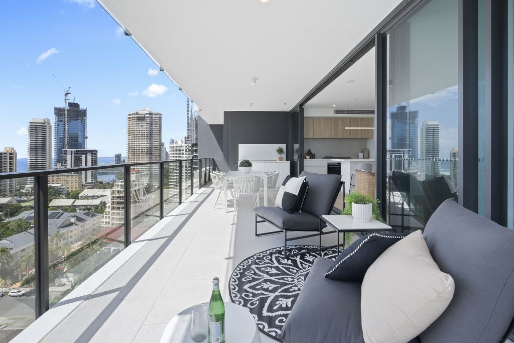 A balcony with a couch and chairs and a view of the city