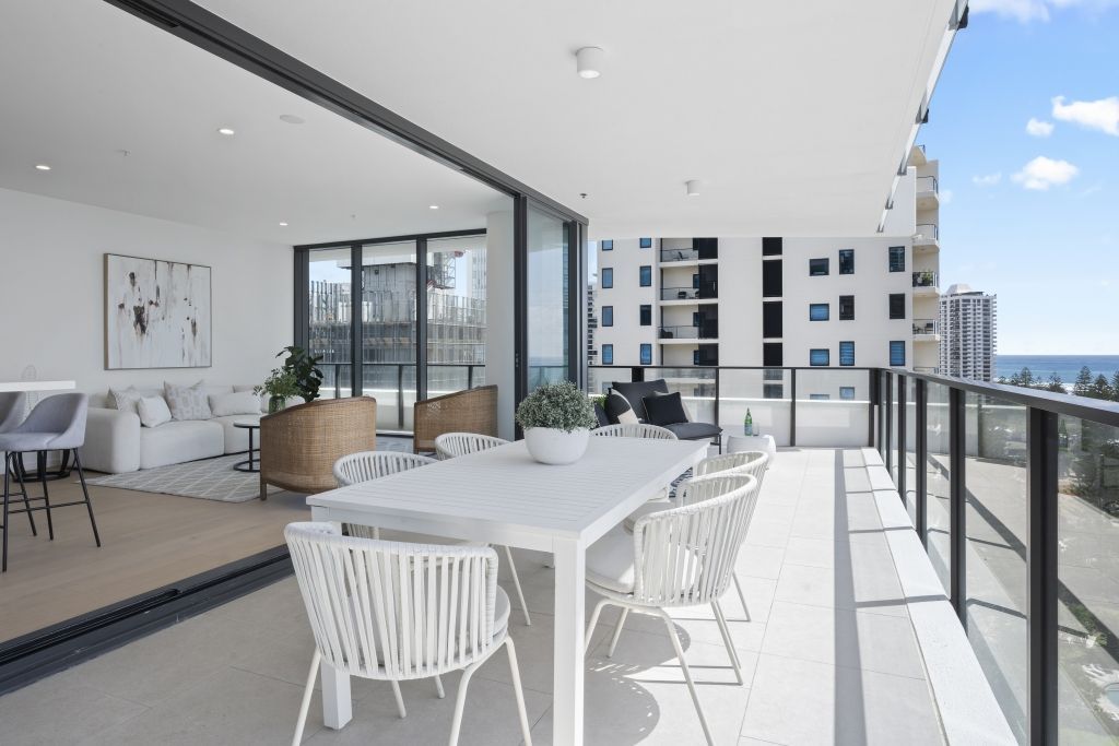 There is a large balcony with a table and chairs on it.