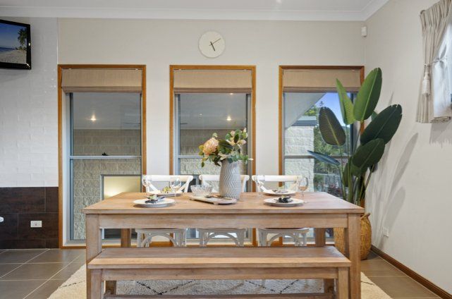 A dining room table with a vase of flowers on it