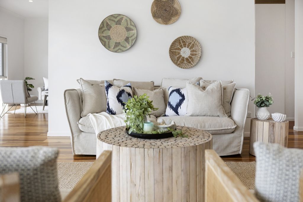 A living room with a white couch and a wooden table