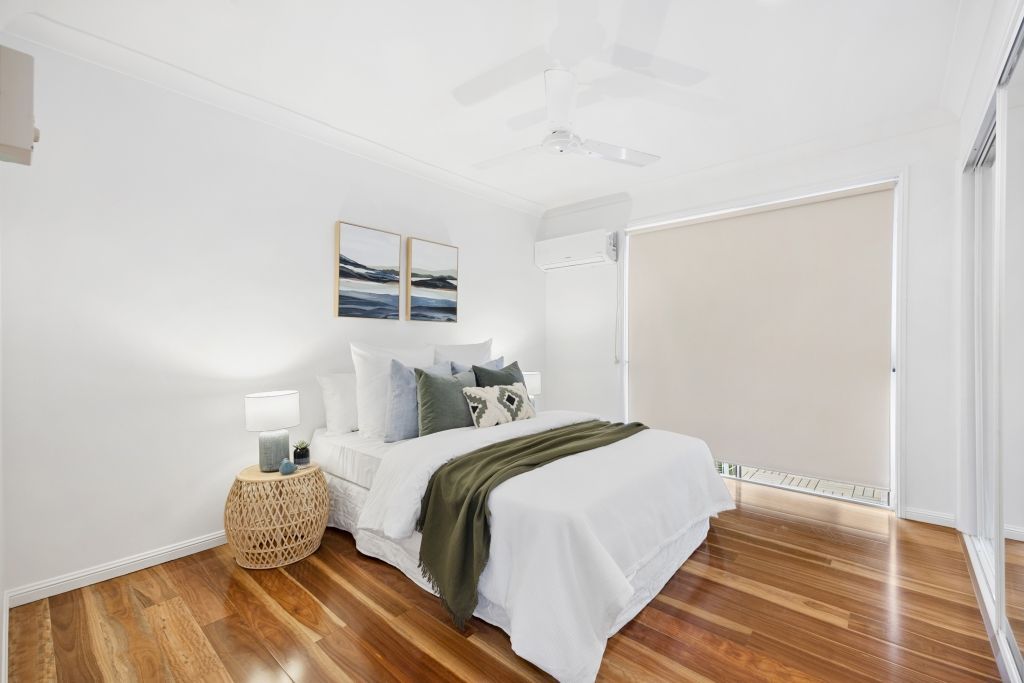 A bedroom with a bed , a nightstand , and a ceiling fan.