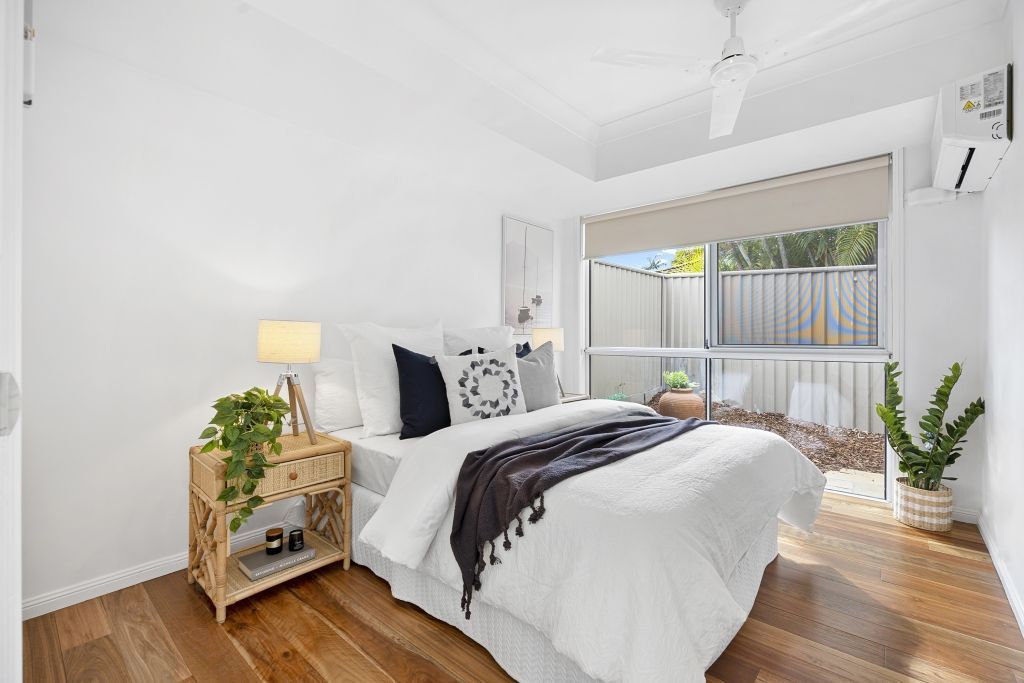 A bedroom with a bed , nightstand , and ceiling fan.