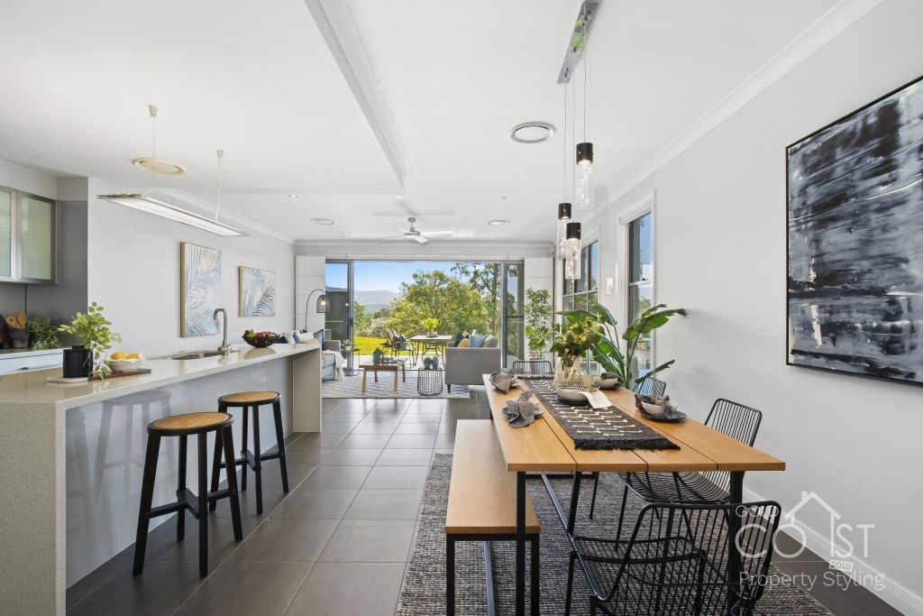 A kitchen and dining room in a house with a table and stools.