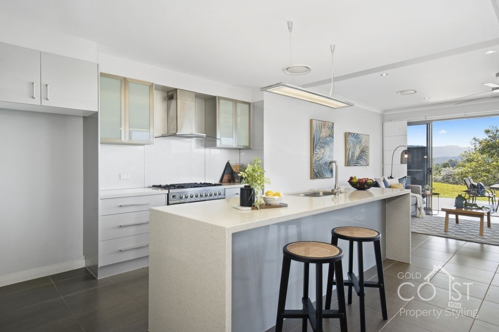 A kitchen with a large island and two stools.