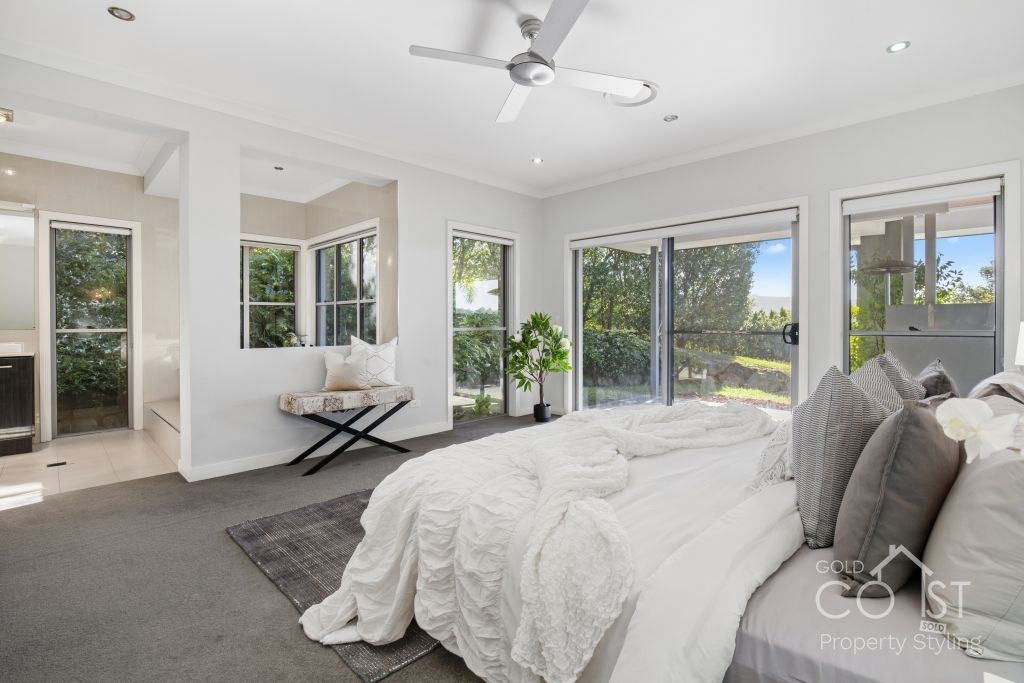 A bedroom with a large bed and a ceiling fan.