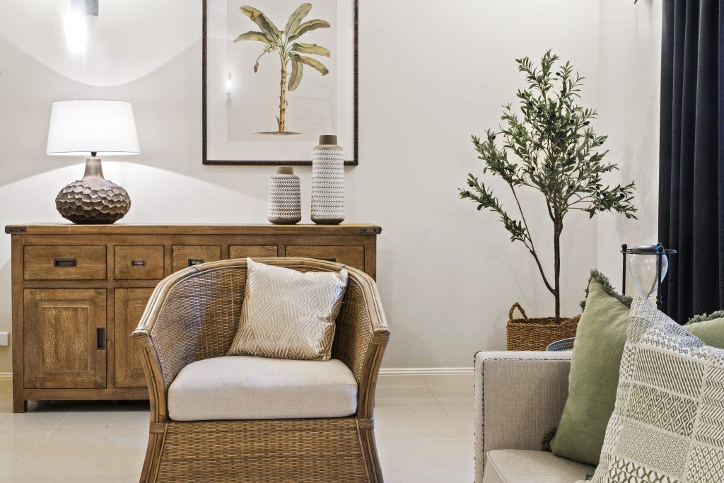 A living room with a wicker chair and a couch