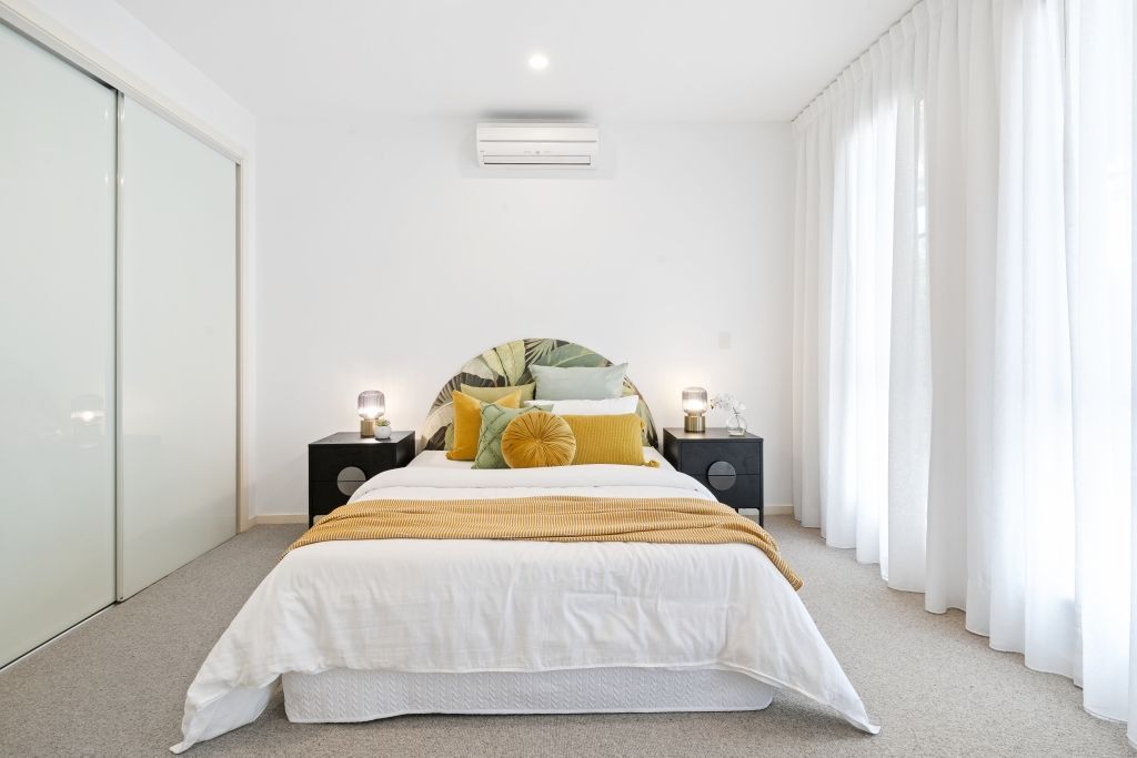 A bedroom with a large bed and sliding glass doors.