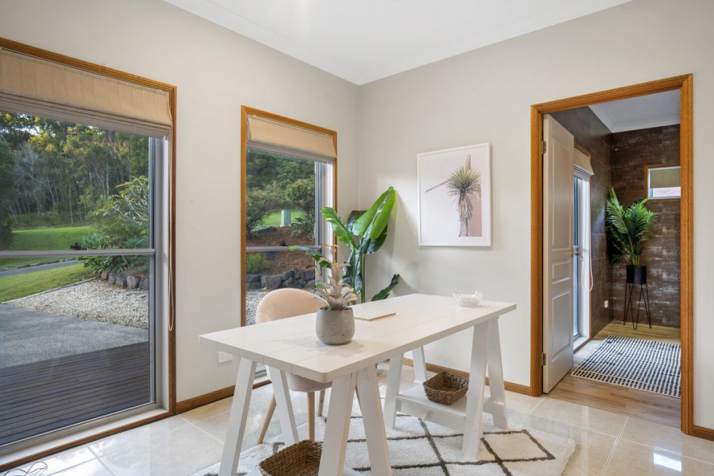 A dining room with a table and chairs and a sliding glass door.