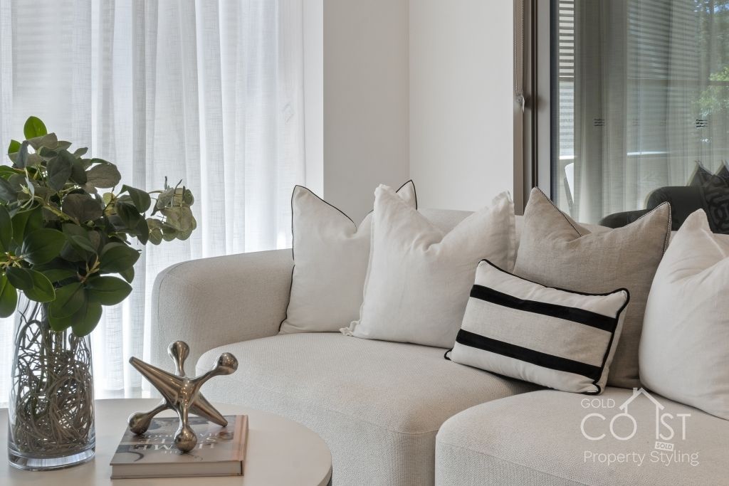 A living room with a couch and a vase of flowers