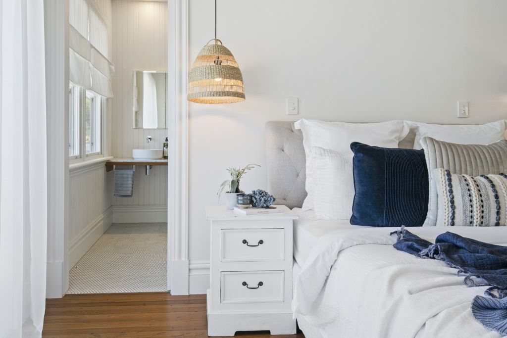 A bedroom with a bed , nightstand , and bathroom.