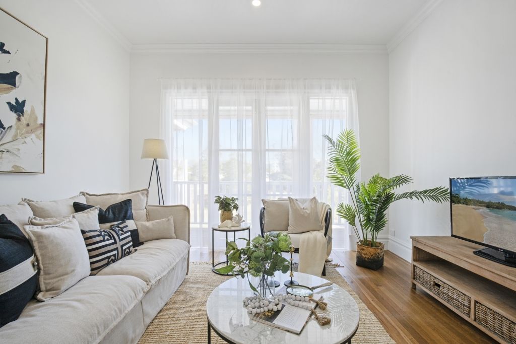A living room with a couch , chair , coffee table and television.