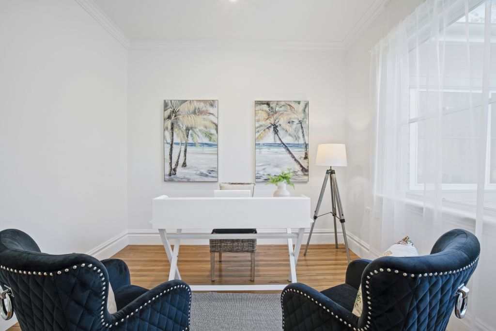 A living room with two chairs and a desk.