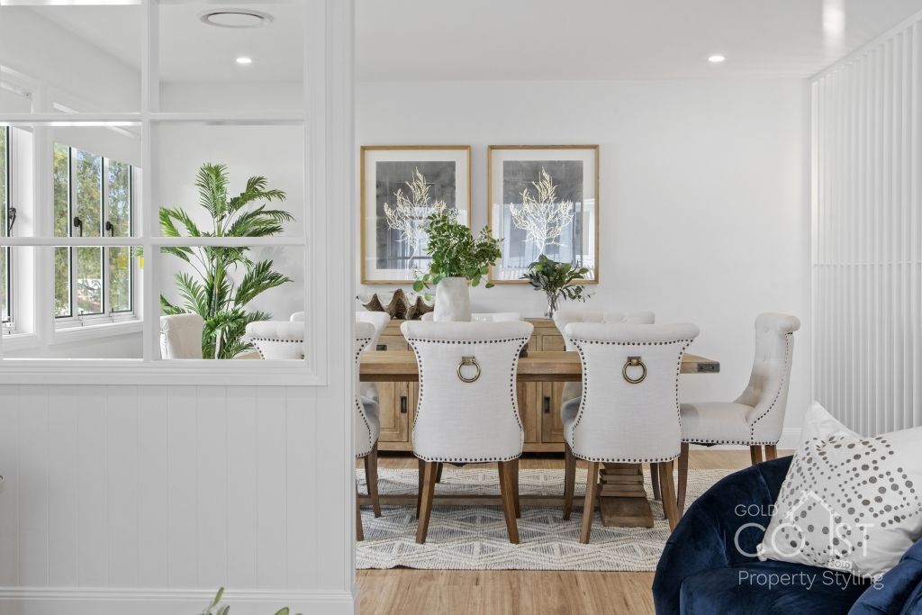 A living room with a dining room table and chairs and a blue chair.
