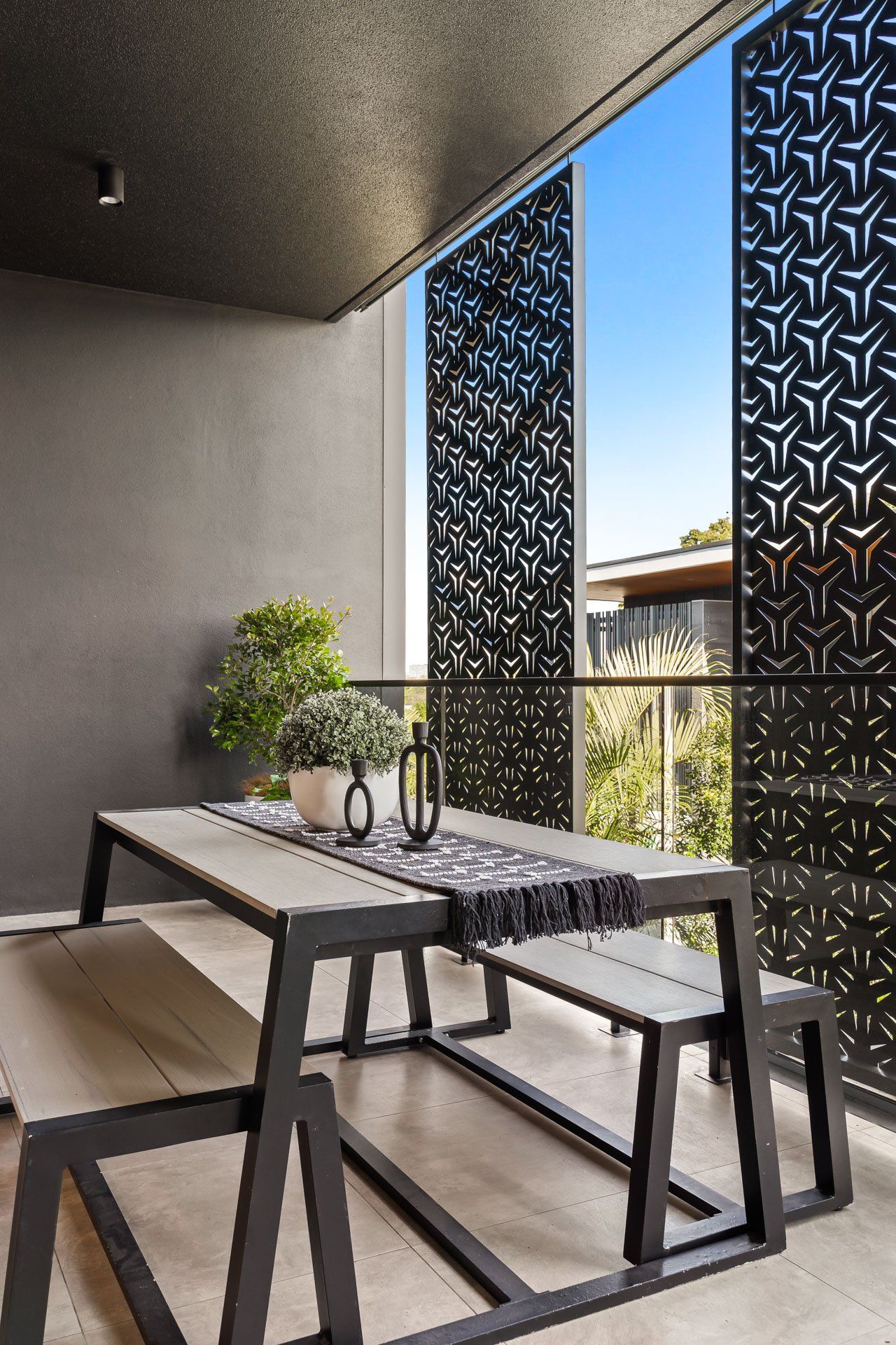 A balcony with a table and benches on it.