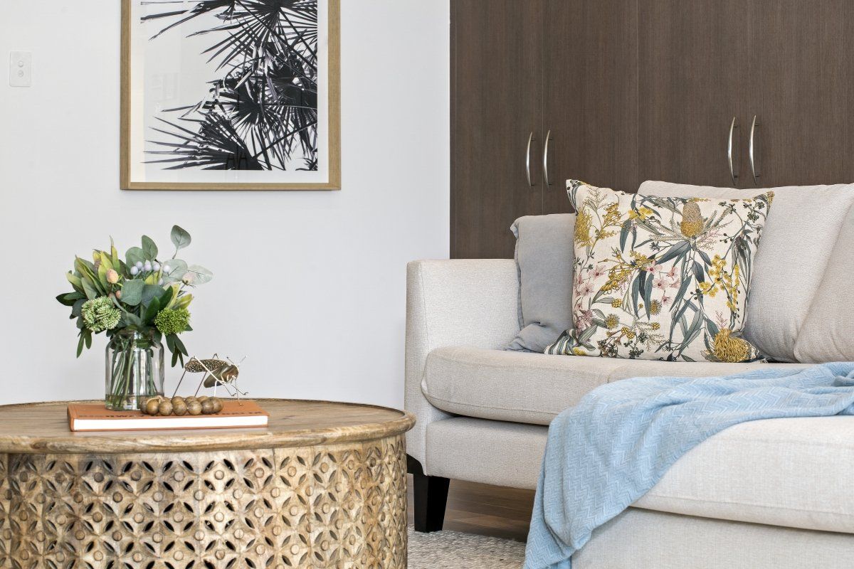 A living room with a couch , coffee table , and a picture on the wall.