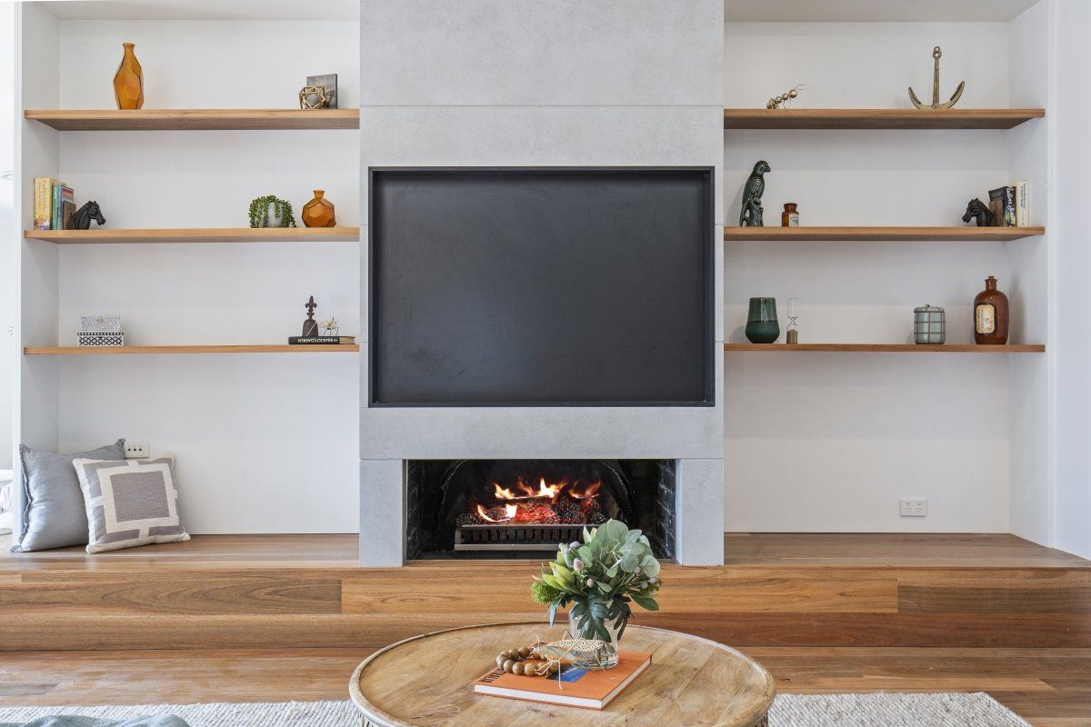 A living room with a fireplace and a flat screen tv.