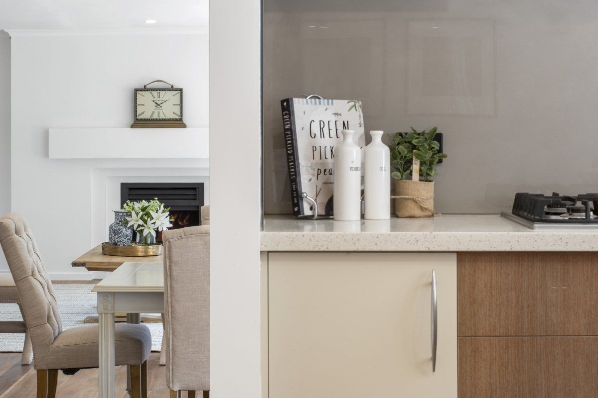 A kitchen with a table and chairs and a clock on the wall.