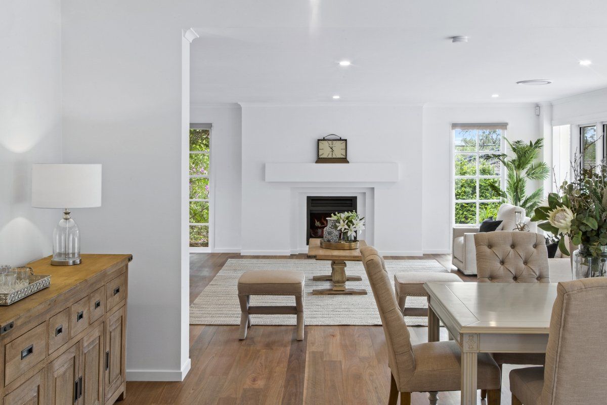 A living room with a table and chairs and a fireplace