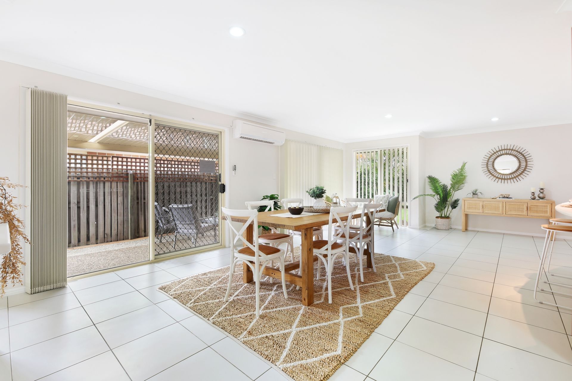 A dining room with a table and chairs and a rug.