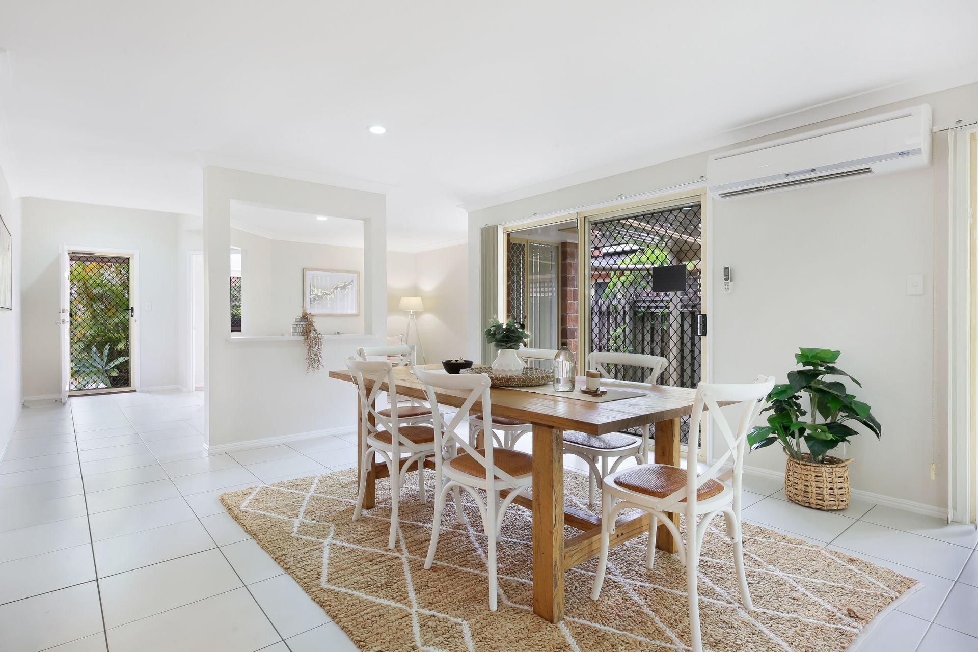 A dining room with a wooden table and chairs and a rug.