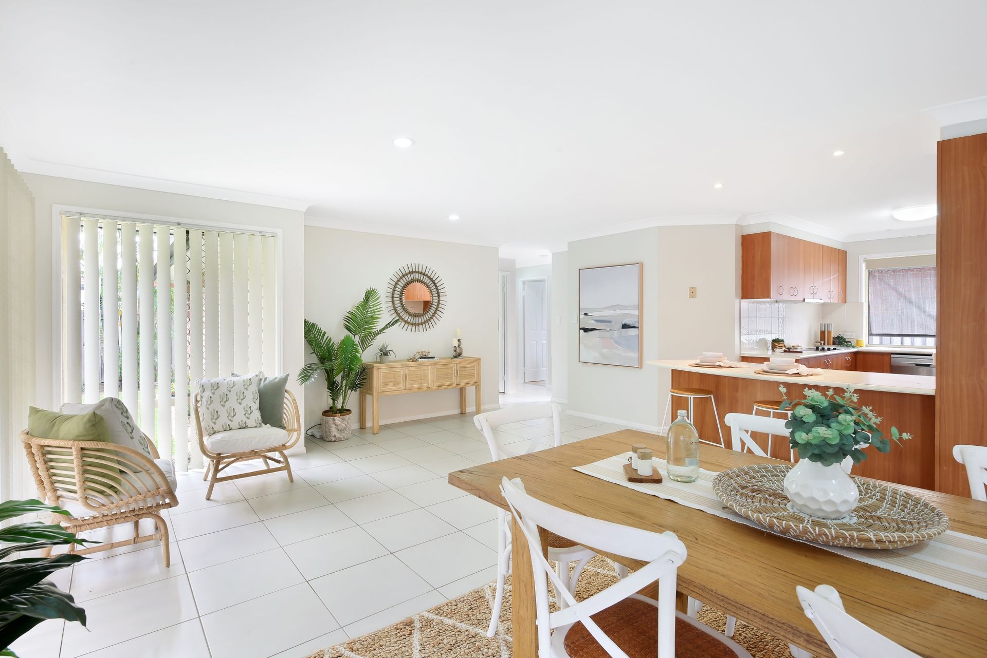 A living room with a dining table and chairs and a kitchen.