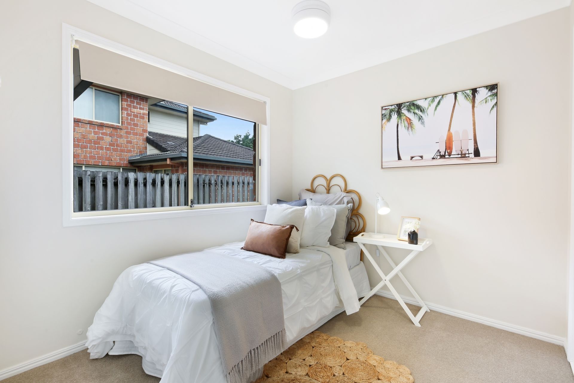 A bedroom with a single bed and a window.