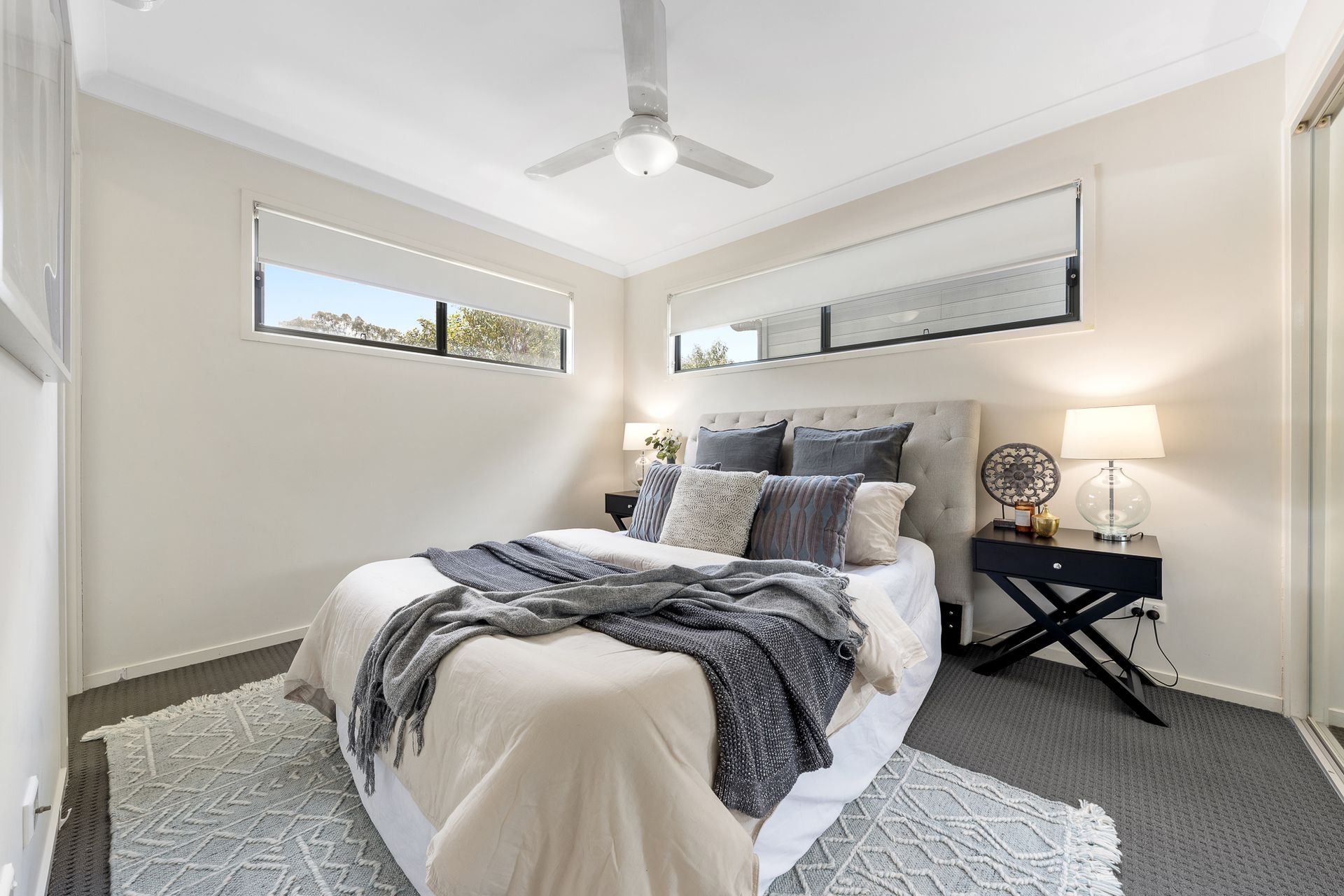 A bedroom with a bed and a ceiling fan.