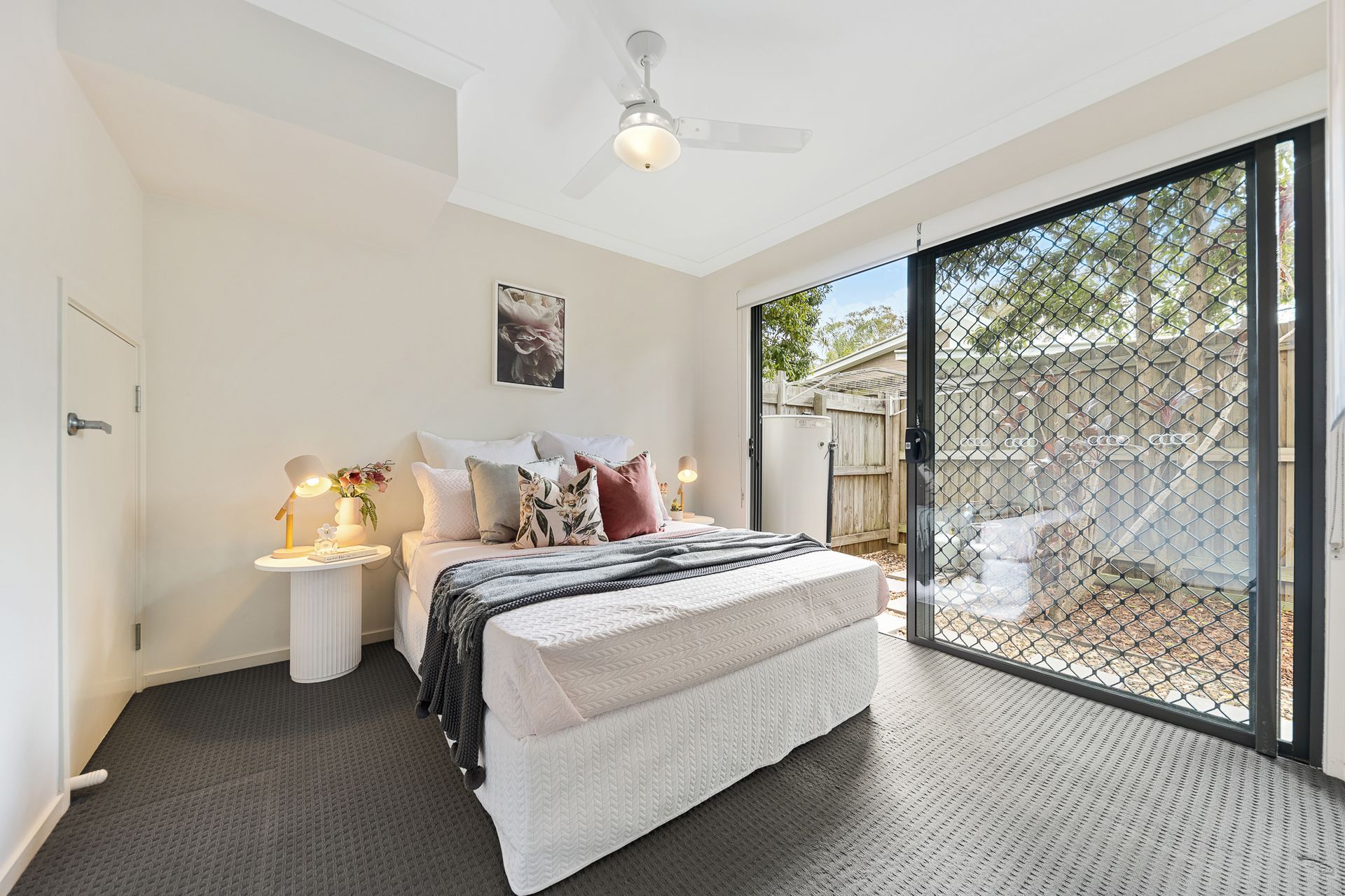 A bedroom with a large bed and a sliding glass door