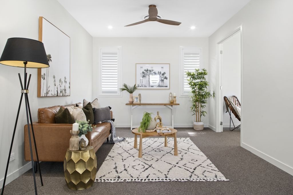 A living room with a brown couch and a white rug