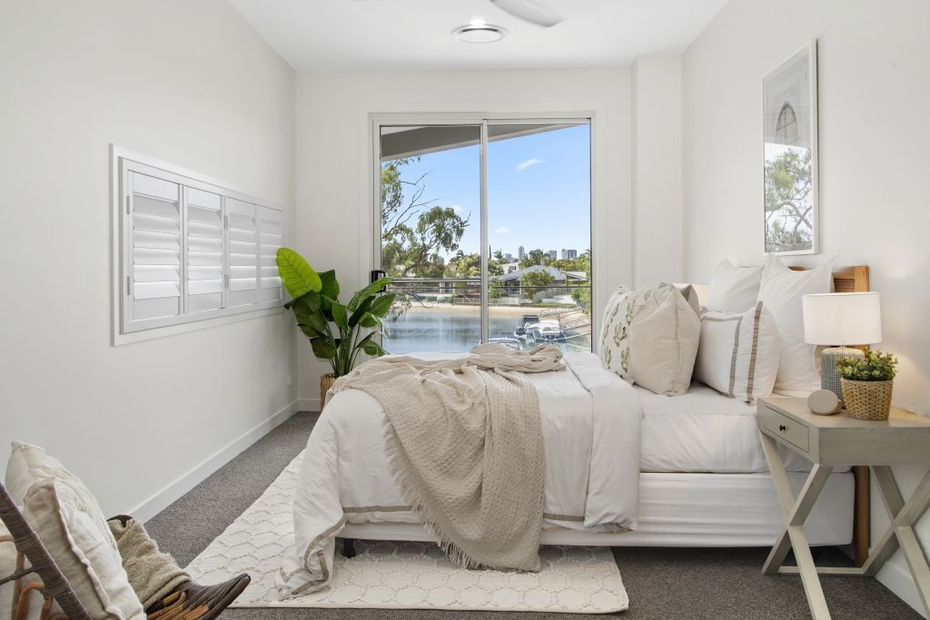 A bedroom with a large bed and a sliding glass door.