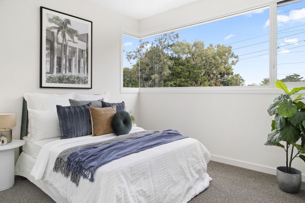 A bedroom with a large bed and a large window.