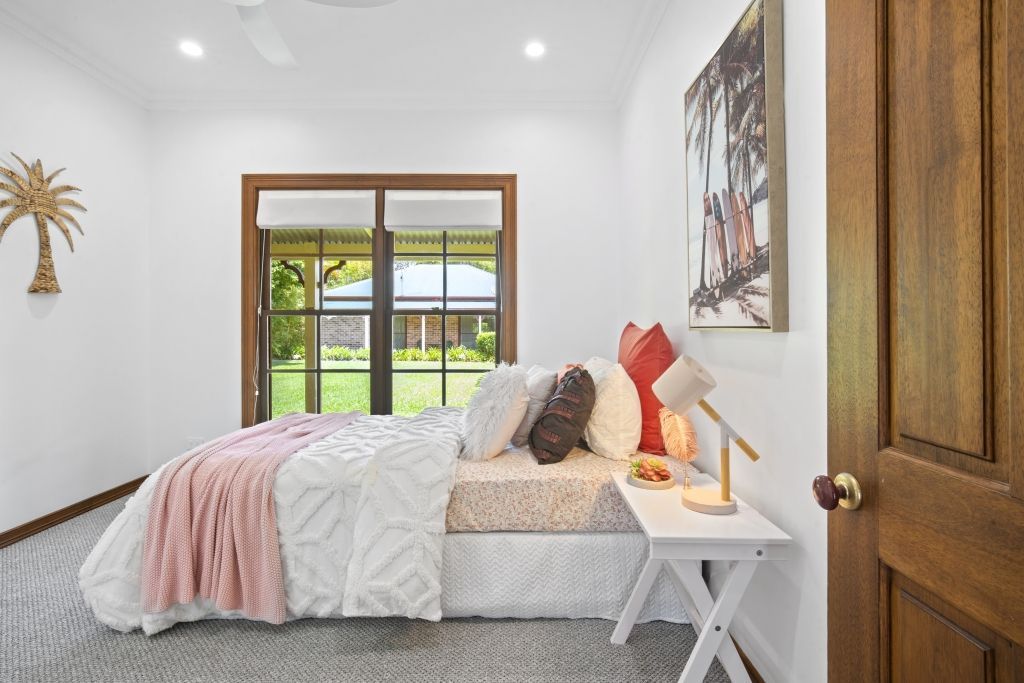 A bedroom with a bed , nightstand , and sliding glass doors.