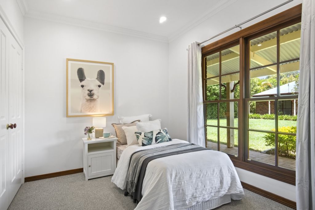 A bedroom with a bed and a picture of a dog on the wall.
