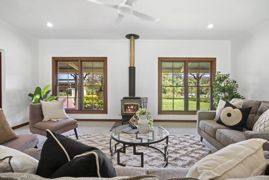 A living room with a couch , chair , coffee table and fireplace.