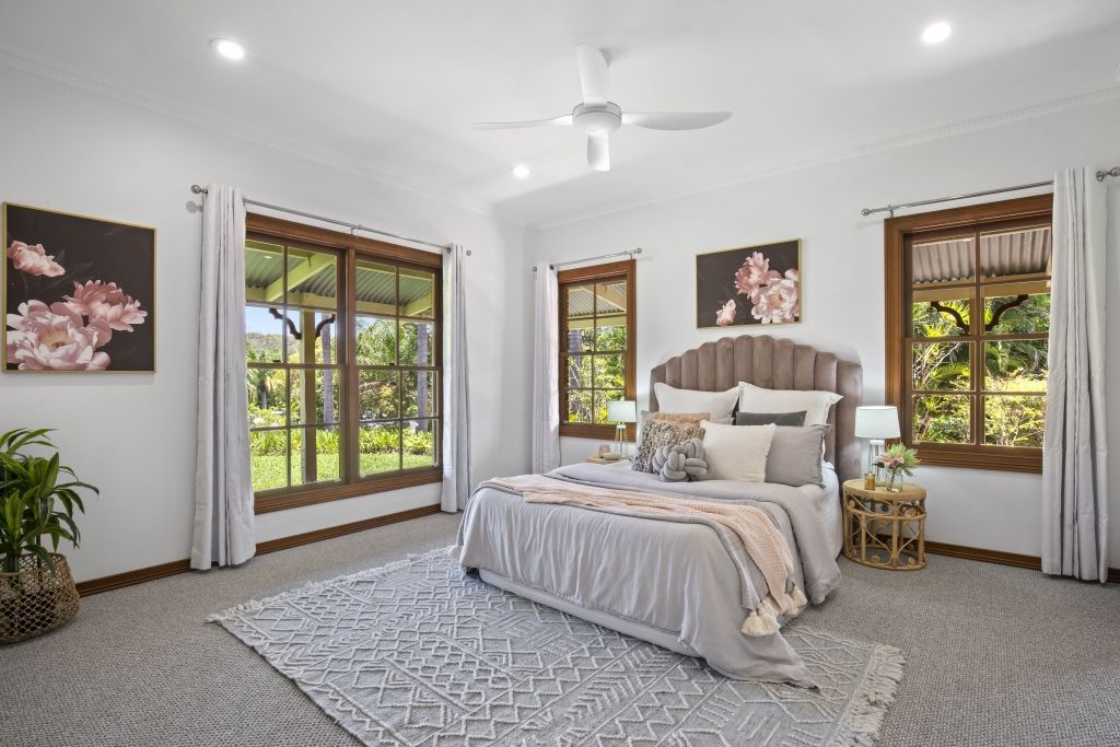 A bedroom with a large bed and a ceiling fan.
