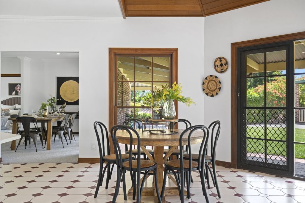 A dining room with a table and chairs and a sliding glass door.