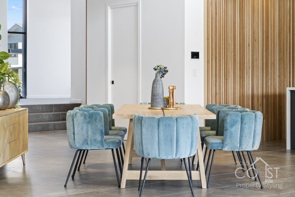 A dining room with a wooden table and blue chairs.