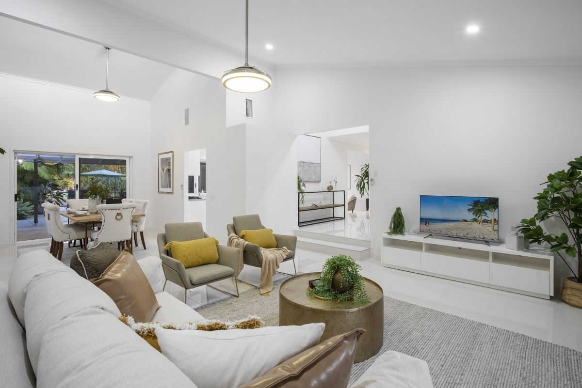A living room with a couch , chairs , coffee table and television.