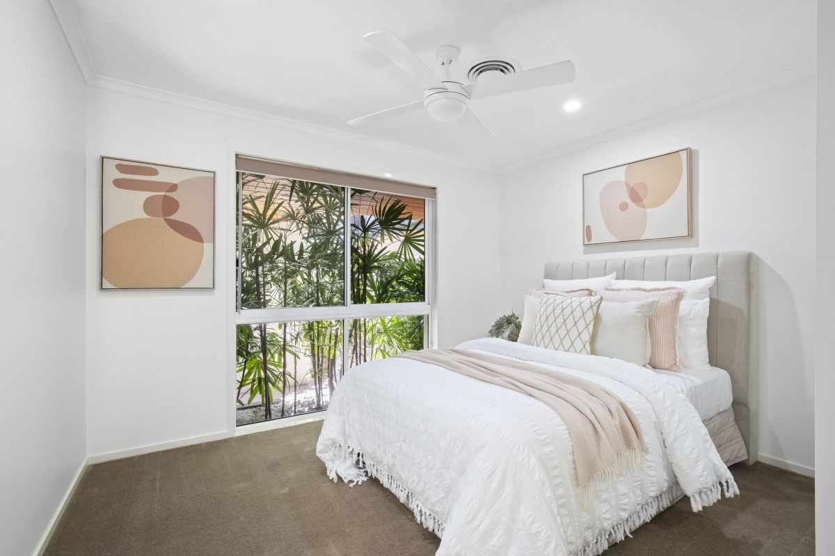 A bedroom with a bed and a ceiling fan.