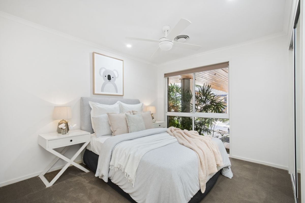 A bedroom with a large bed and a ceiling fan.