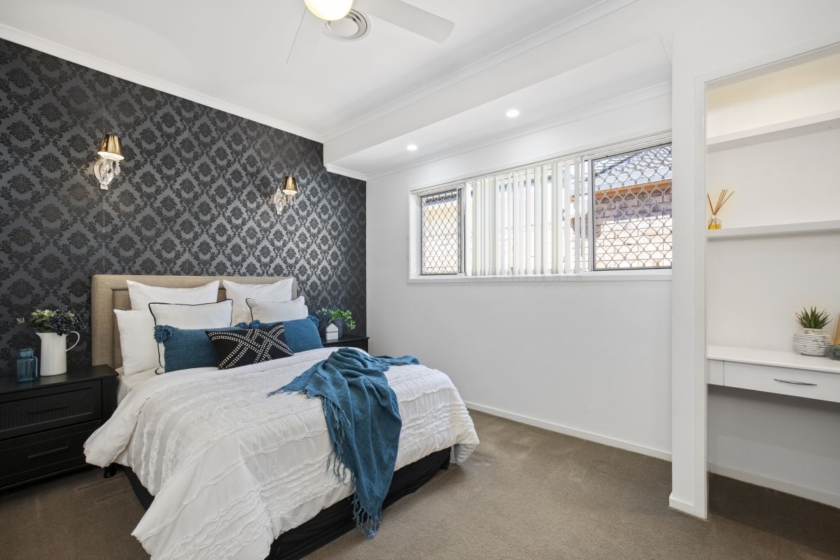 A bedroom with a large bed and a ceiling fan.